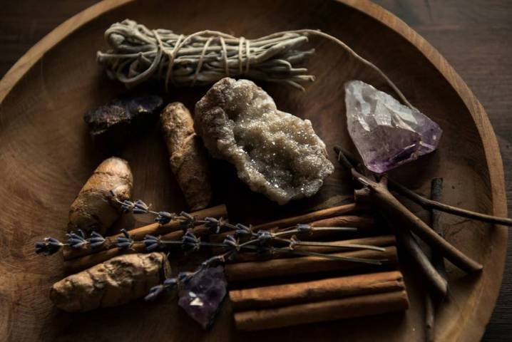 assorted placement of crystal rocks dried herbs sticks placed on a wooden plate